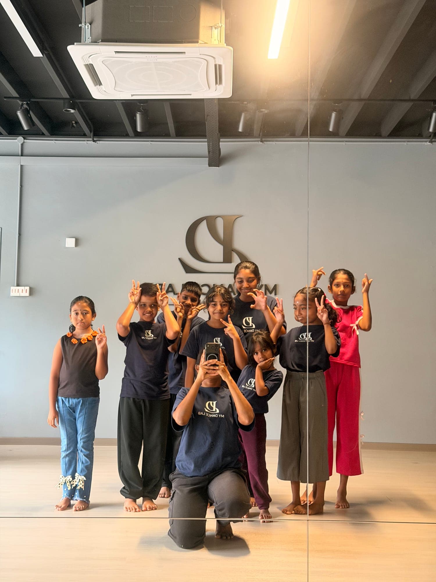 Kids in My Dance Lab T-shirts posing together in front of the studio mirror