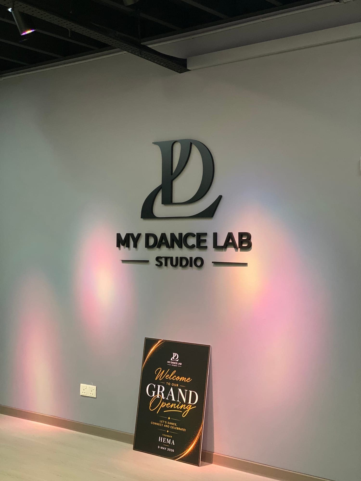 The My Dance Lab Studio logo on a grey wall, with a 'Welcome to our Grand Opening' sign below it